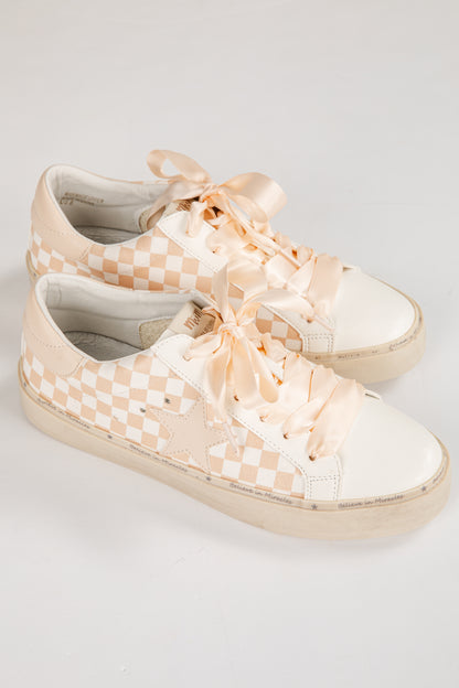 Pair of checkered sneakers with ribbons on a light gray background