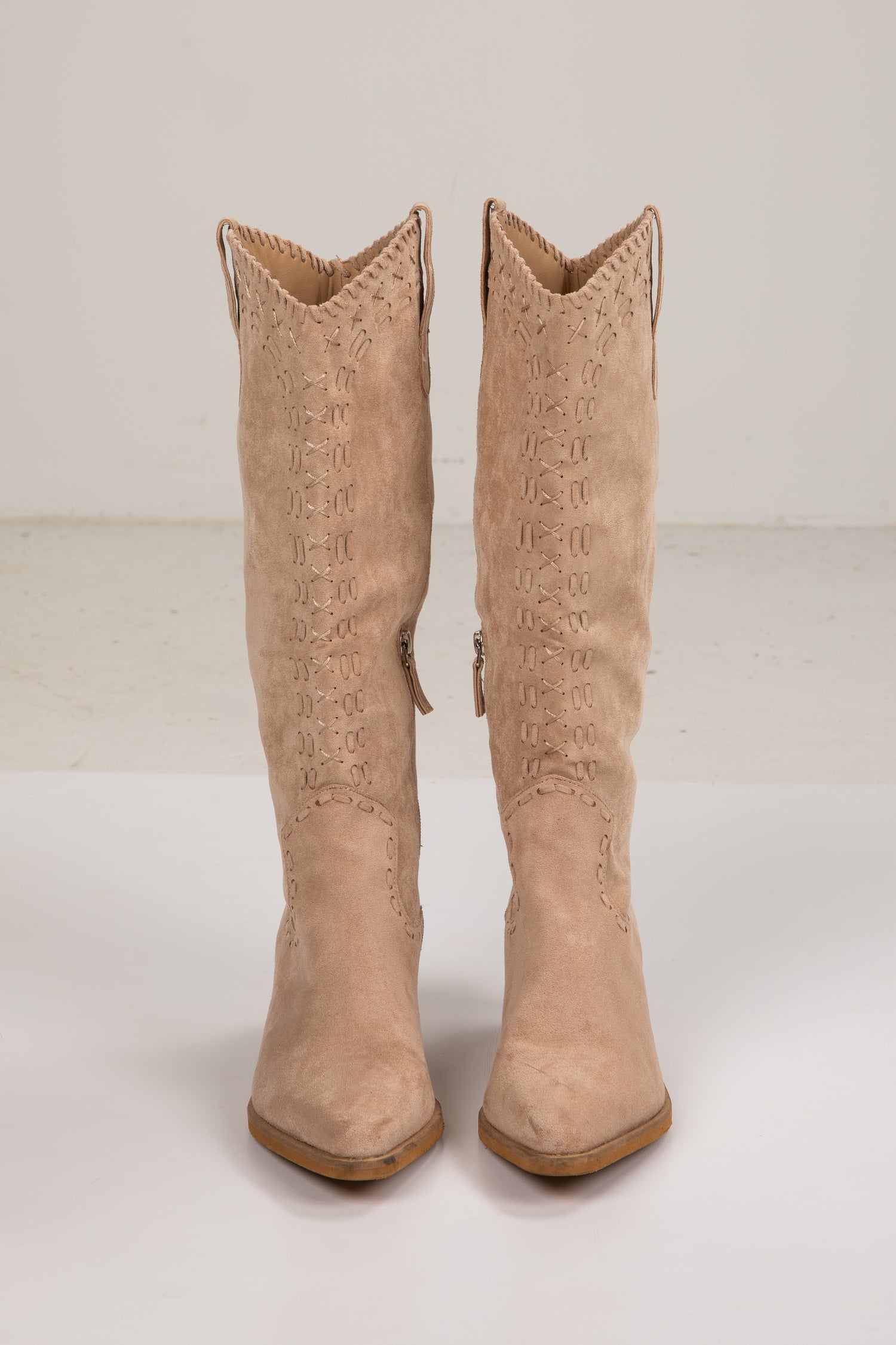Pair of beige cowboy boots on a white background