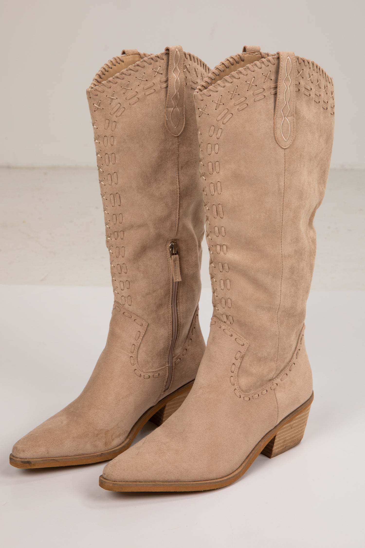 Pair of beige cowboy boots on a white background