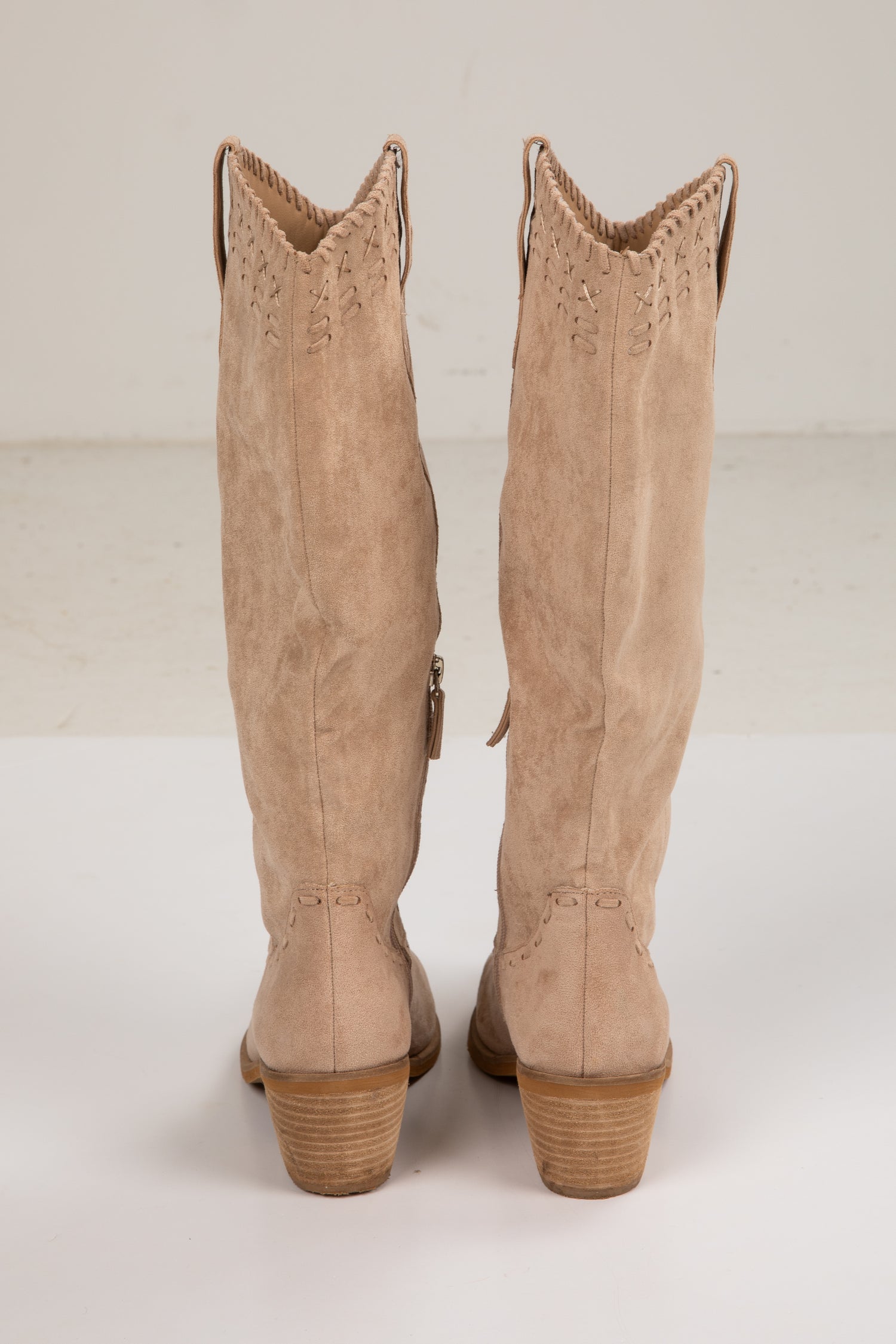 Pair of beige knee-high boots on a white background