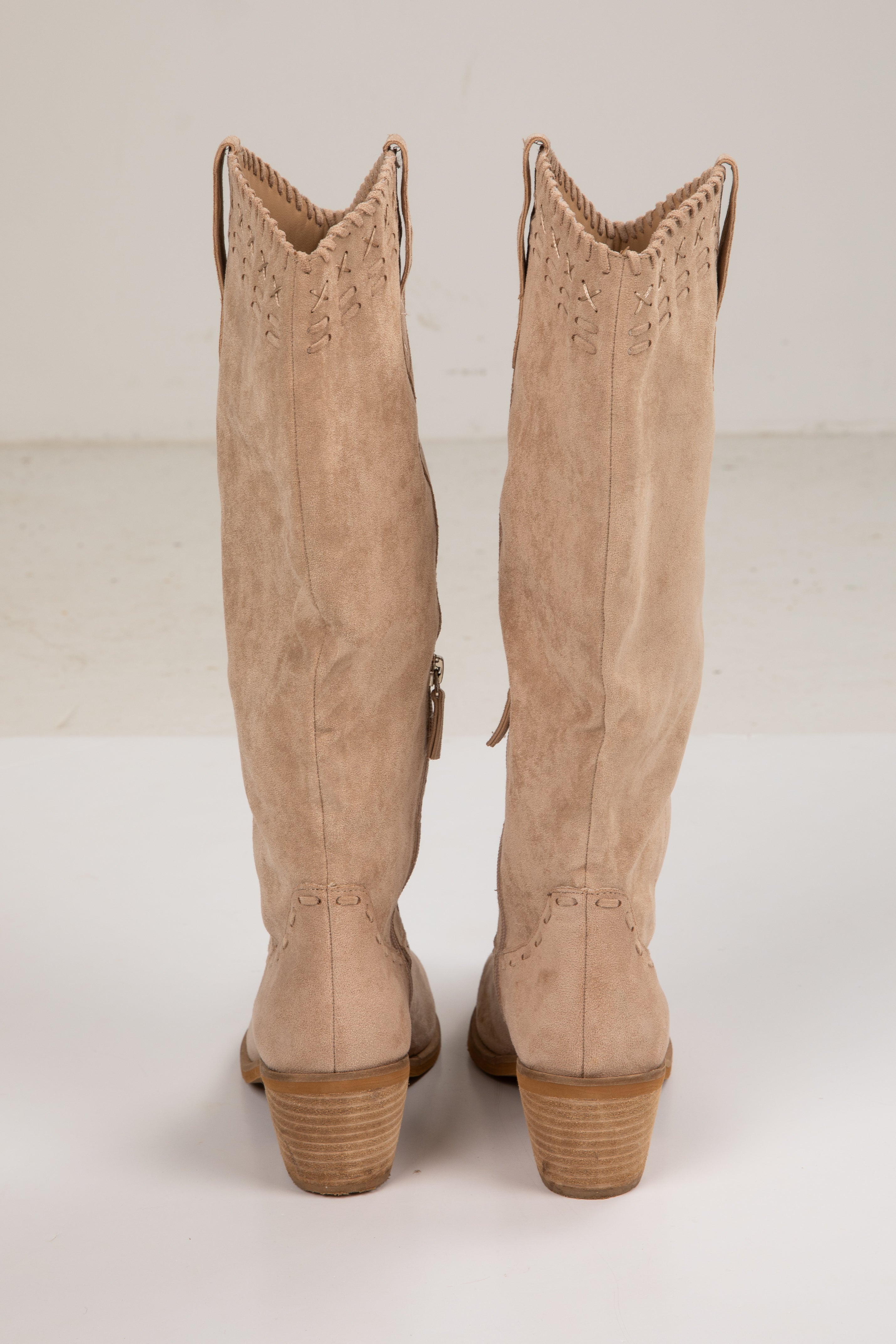 Pair of beige knee-high boots on a white background