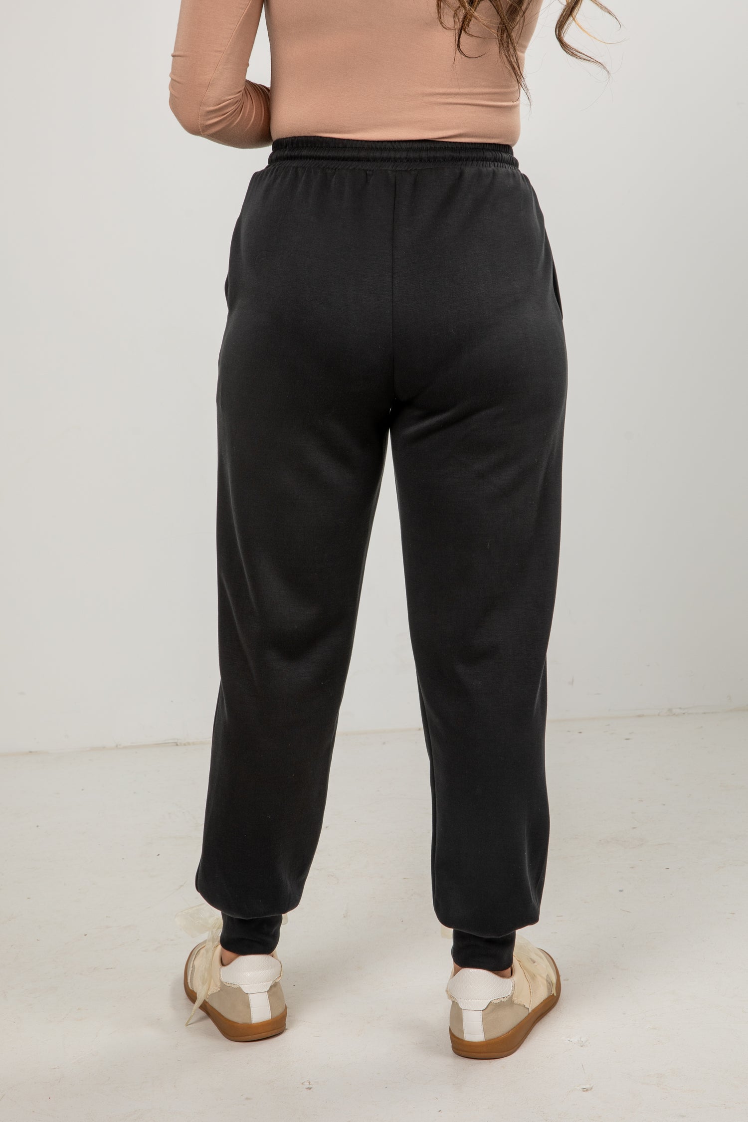 Person wearing black sweatpants on a white background