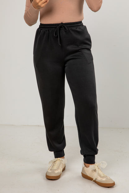 Person wearing black sweatpants on a white background