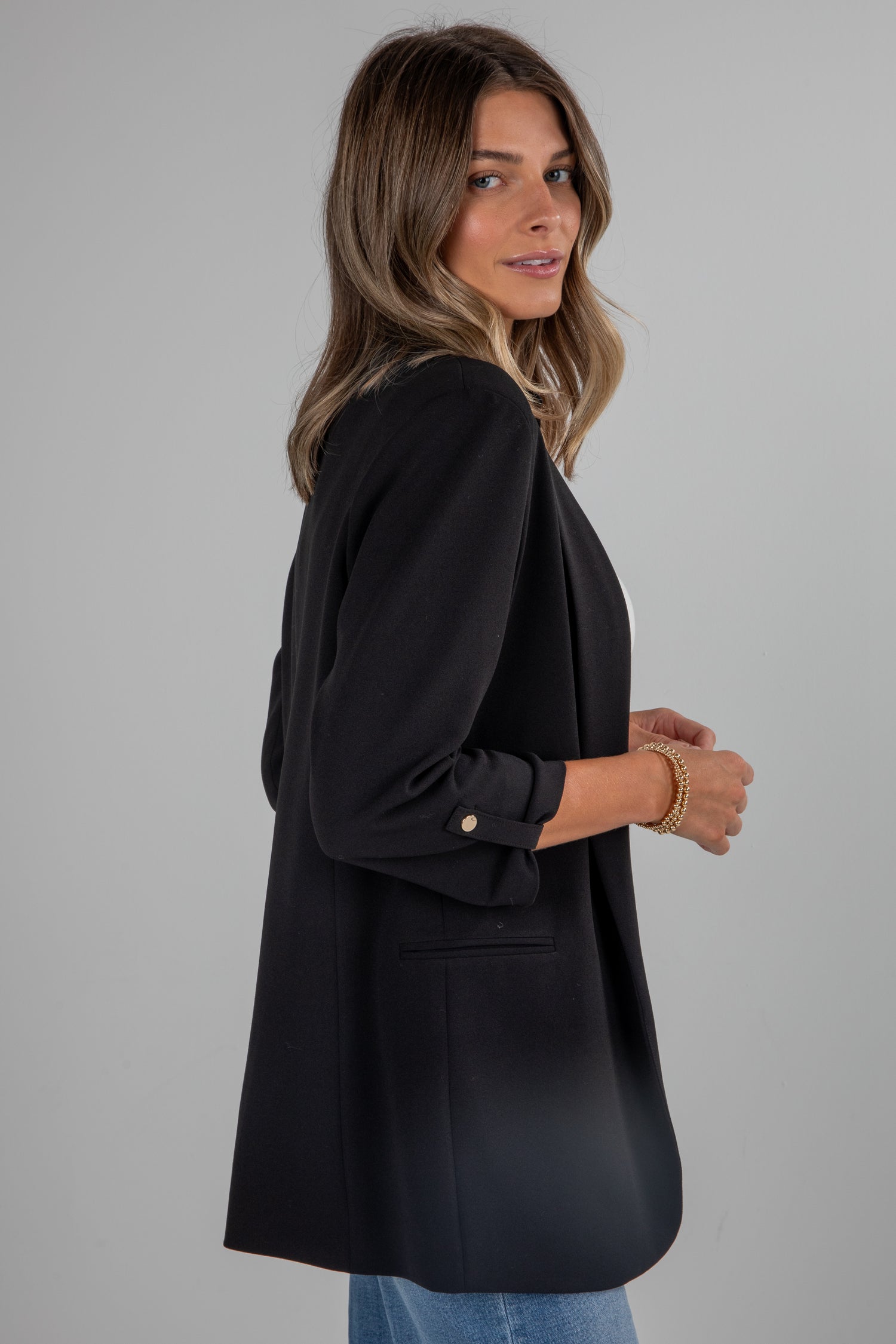 Woman wearing a black blazer against a gray background