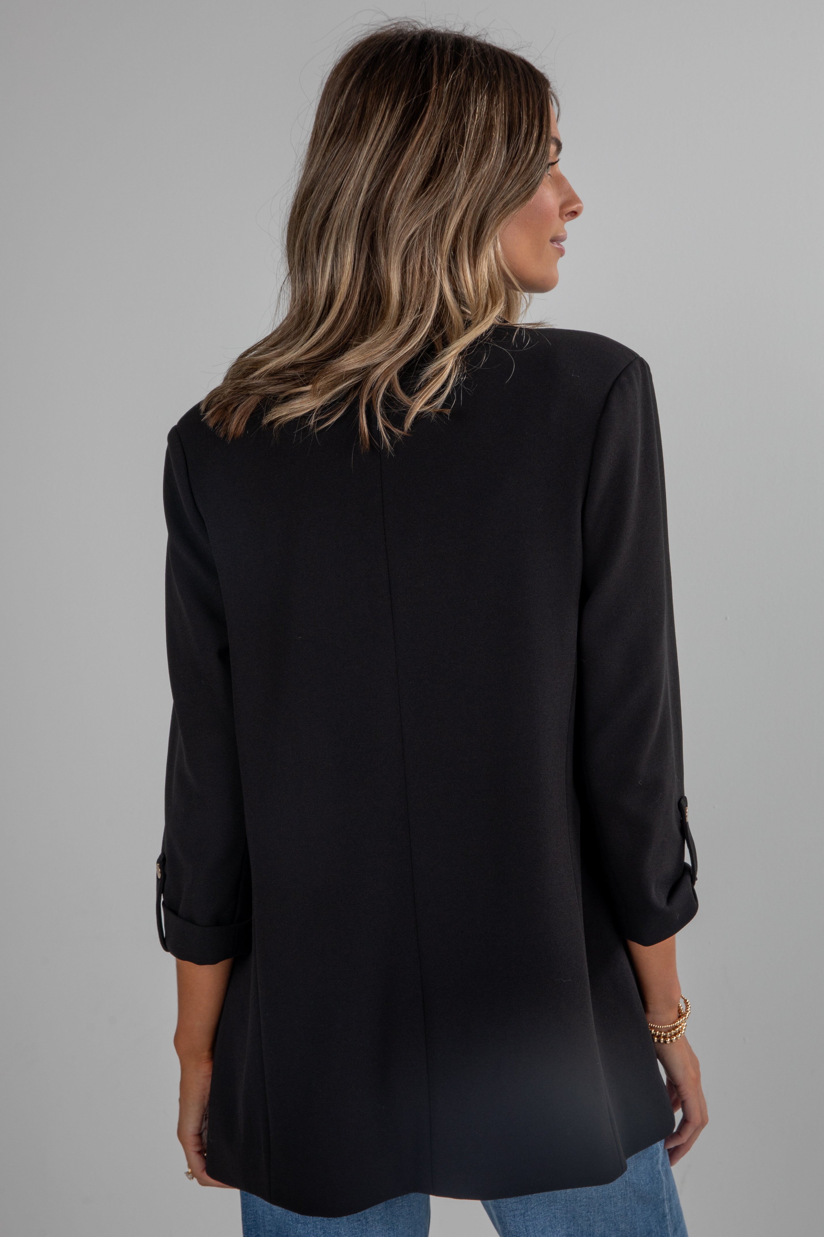 Woman wearing a black long-sleeve top on a gray background