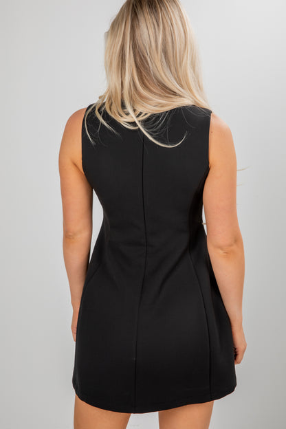 Black sleeveless dress worn by a person on a plain background