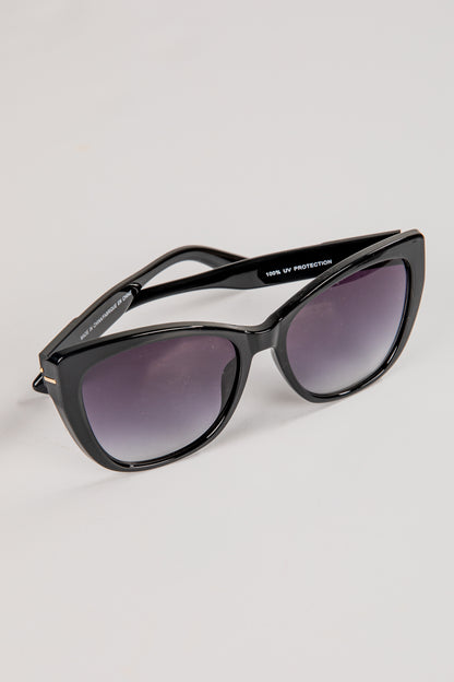 Black sunglasses with dark lenses on a light gray background