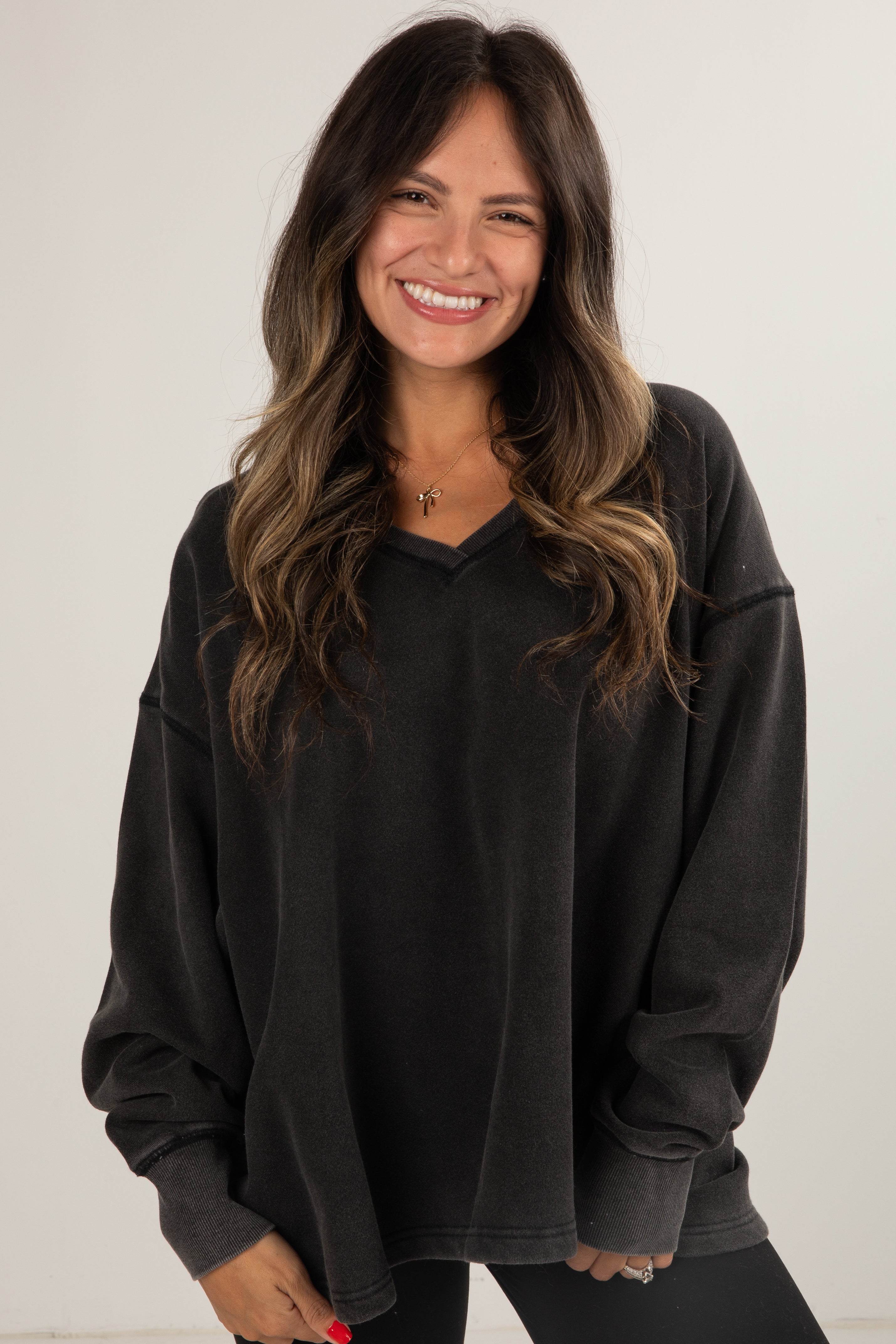 Woman wearing a black oversized sweatshirt against a white background