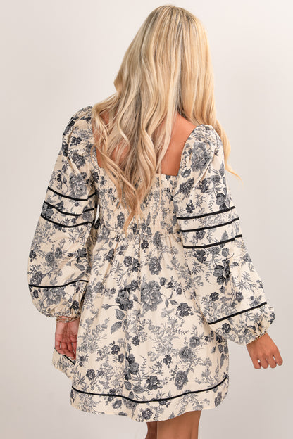 Woman wearing a floral dress with long sleeves on a plain background