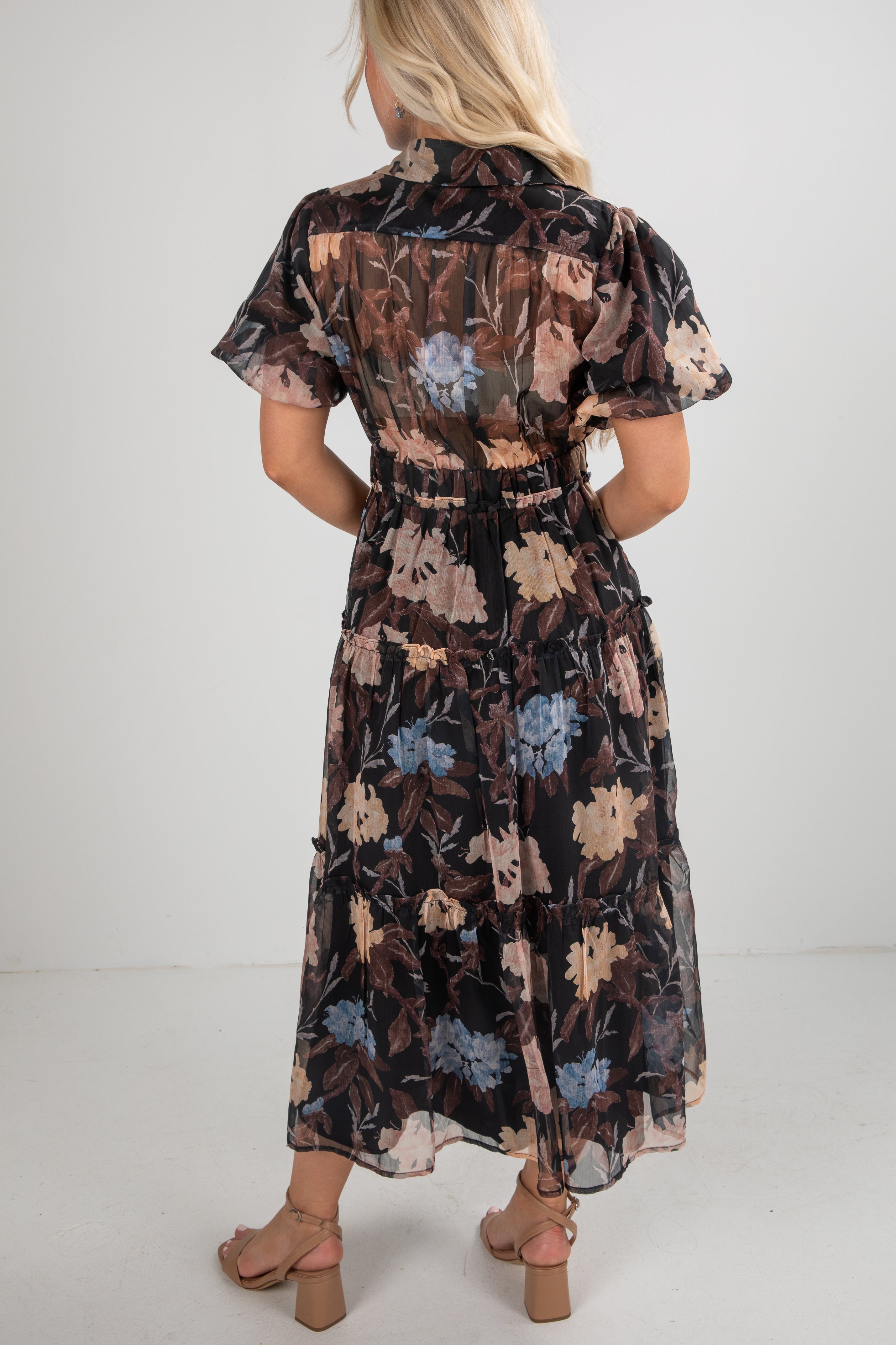 Woman wearing a floral dress with a plain background