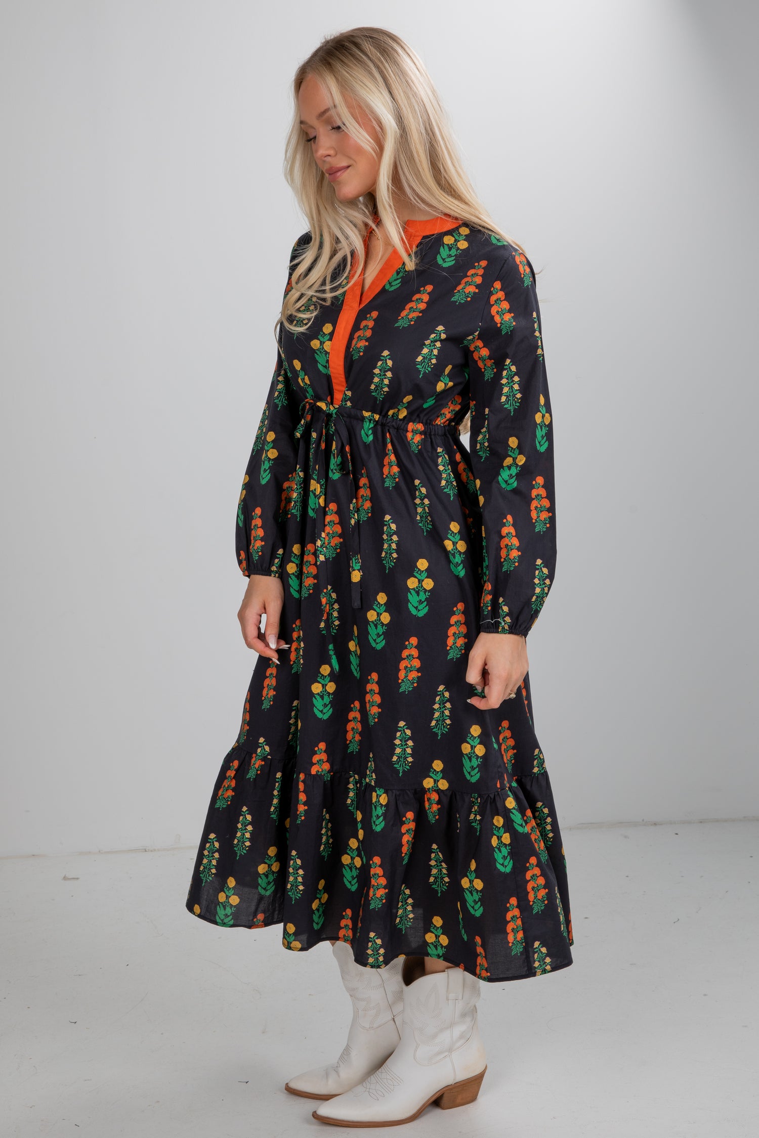 Woman wearing a long-sleeve dress with a floral pattern on a plain background