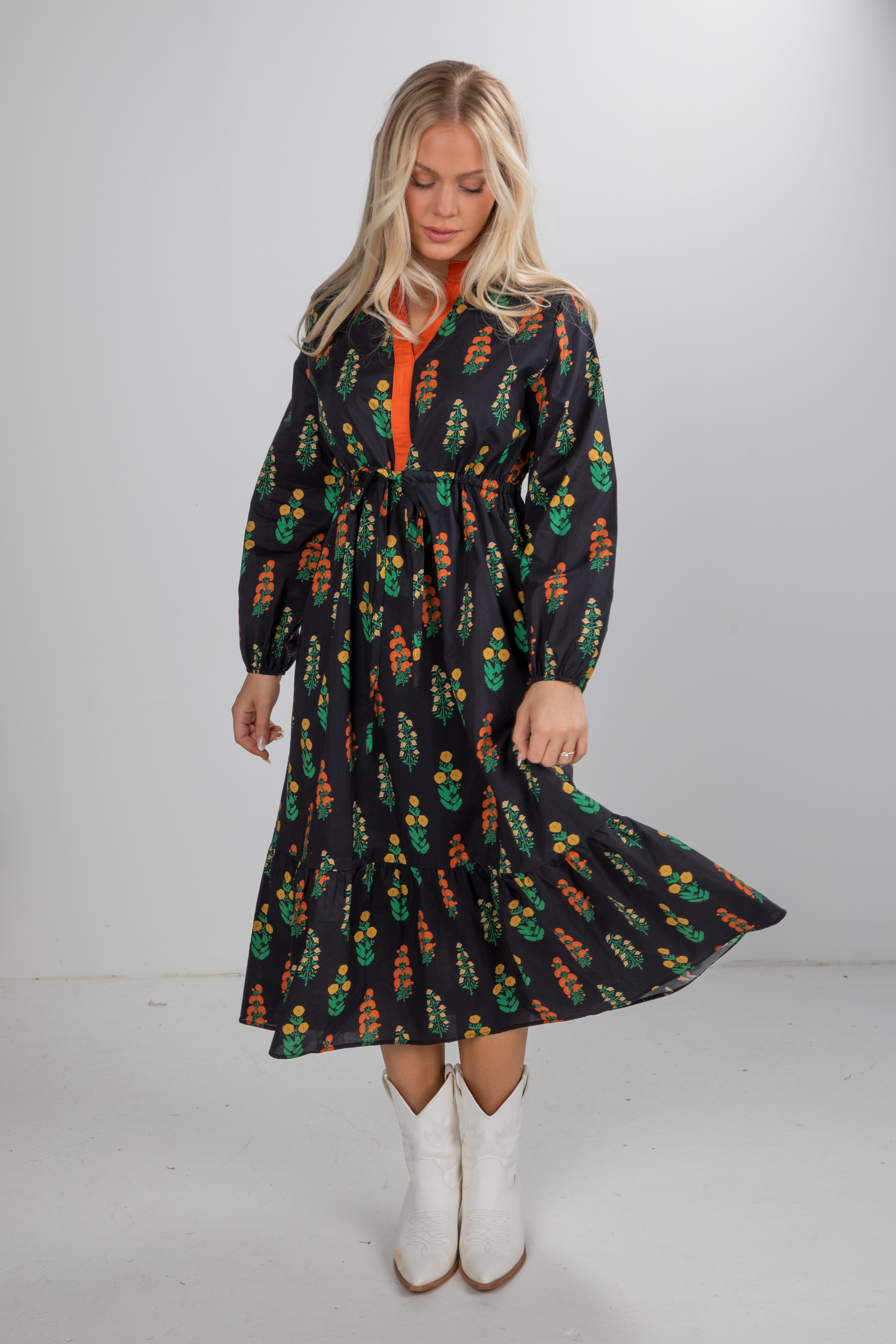 Woman wearing a long-sleeve dress with a colorful pattern on a white background