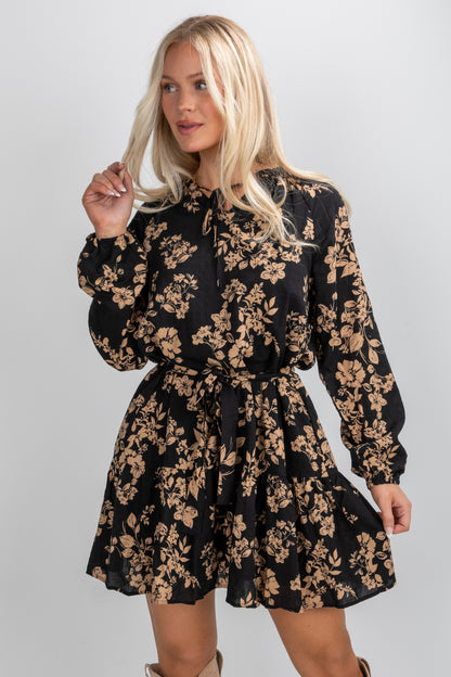 Woman wearing a black floral dress on a gray background