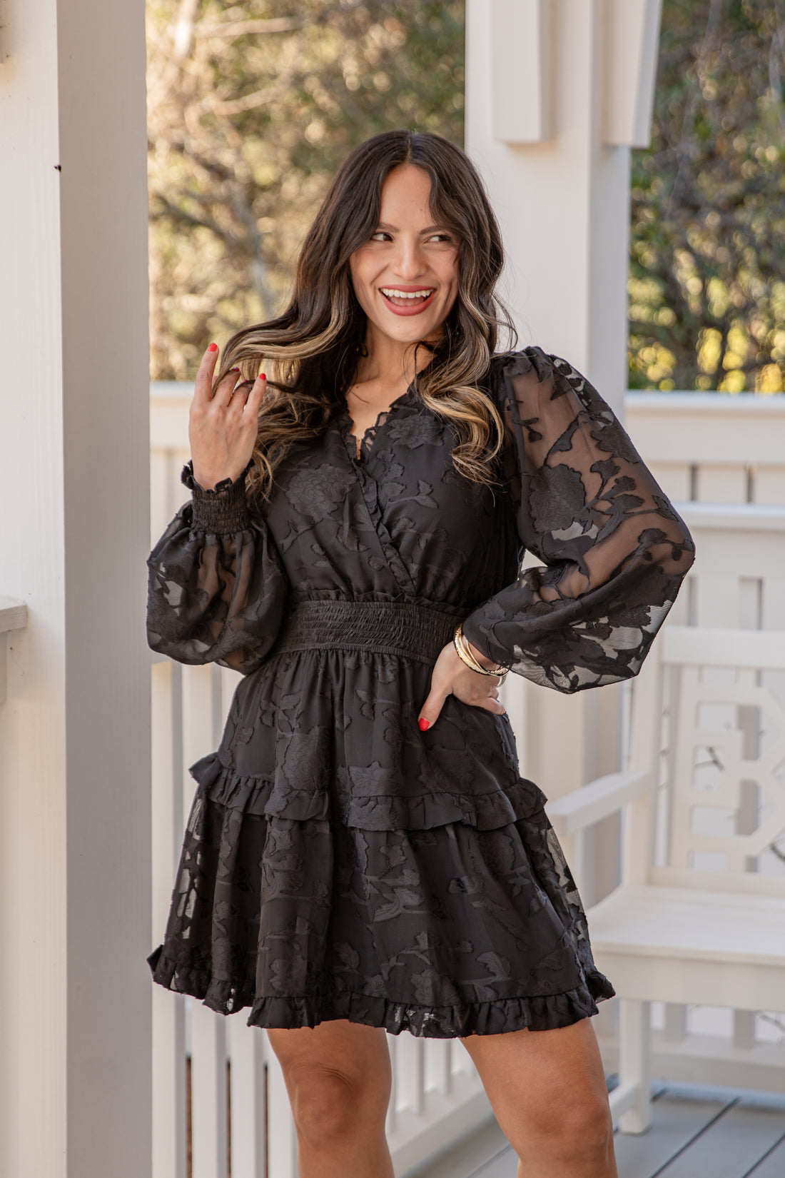Woman wearing a black lace dress on a porch