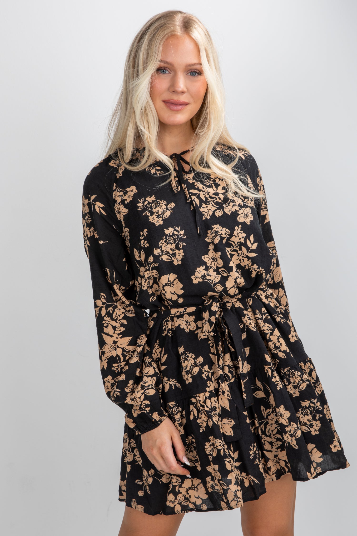 Woman wearing a black floral dress against a white background