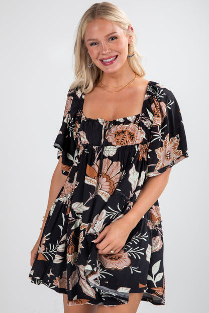 Woman wearing a black floral dress on a white background