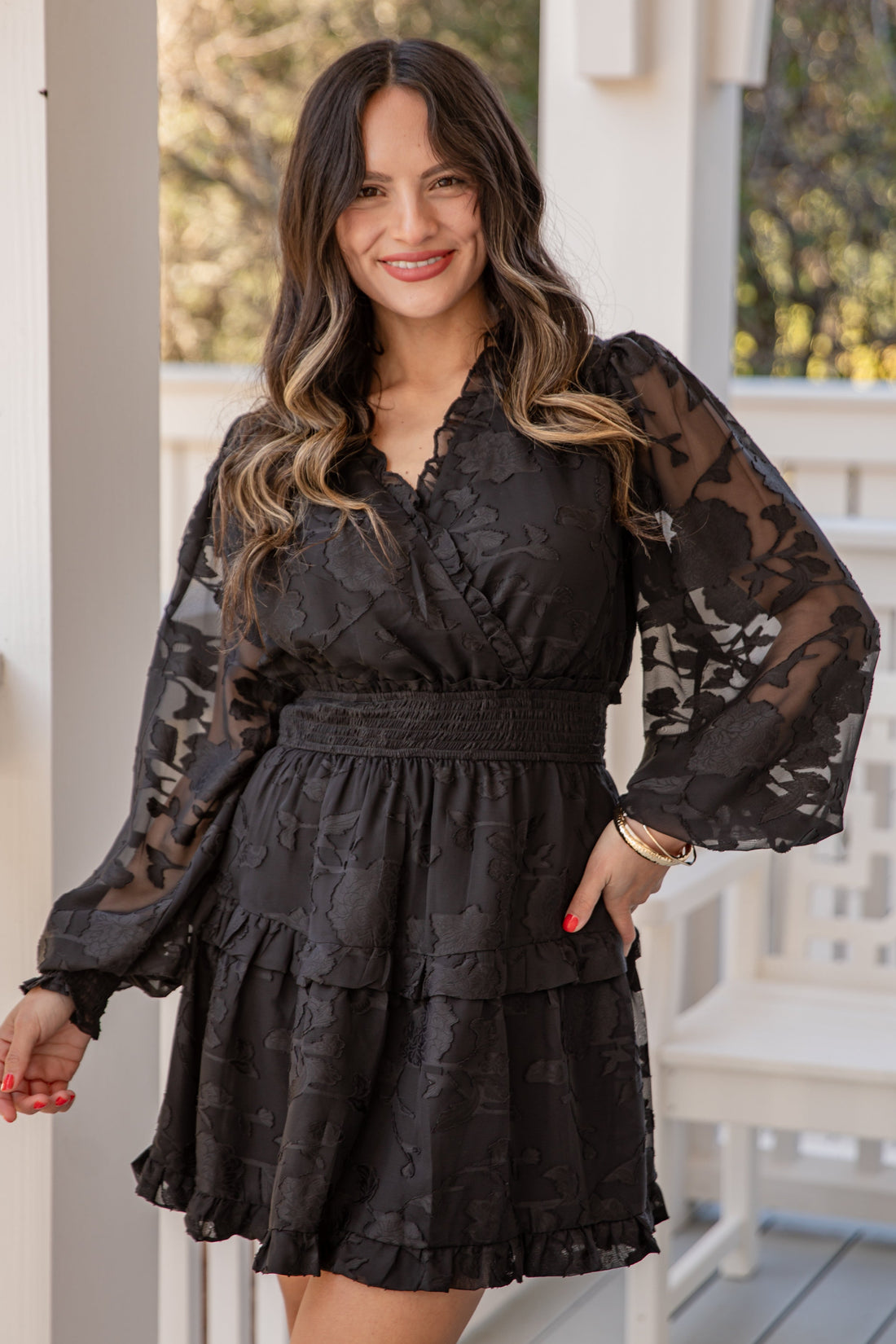 Woman wearing a black lace dress on a porch