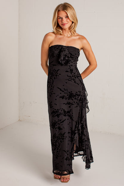 black midi dress features a tonal floral burnout design, delicate strapless fit, and a softly ruffled neckline