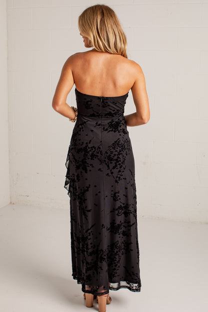 black midi dress features a tonal floral burnout design, delicate strapless fit, and a softly ruffled neckline