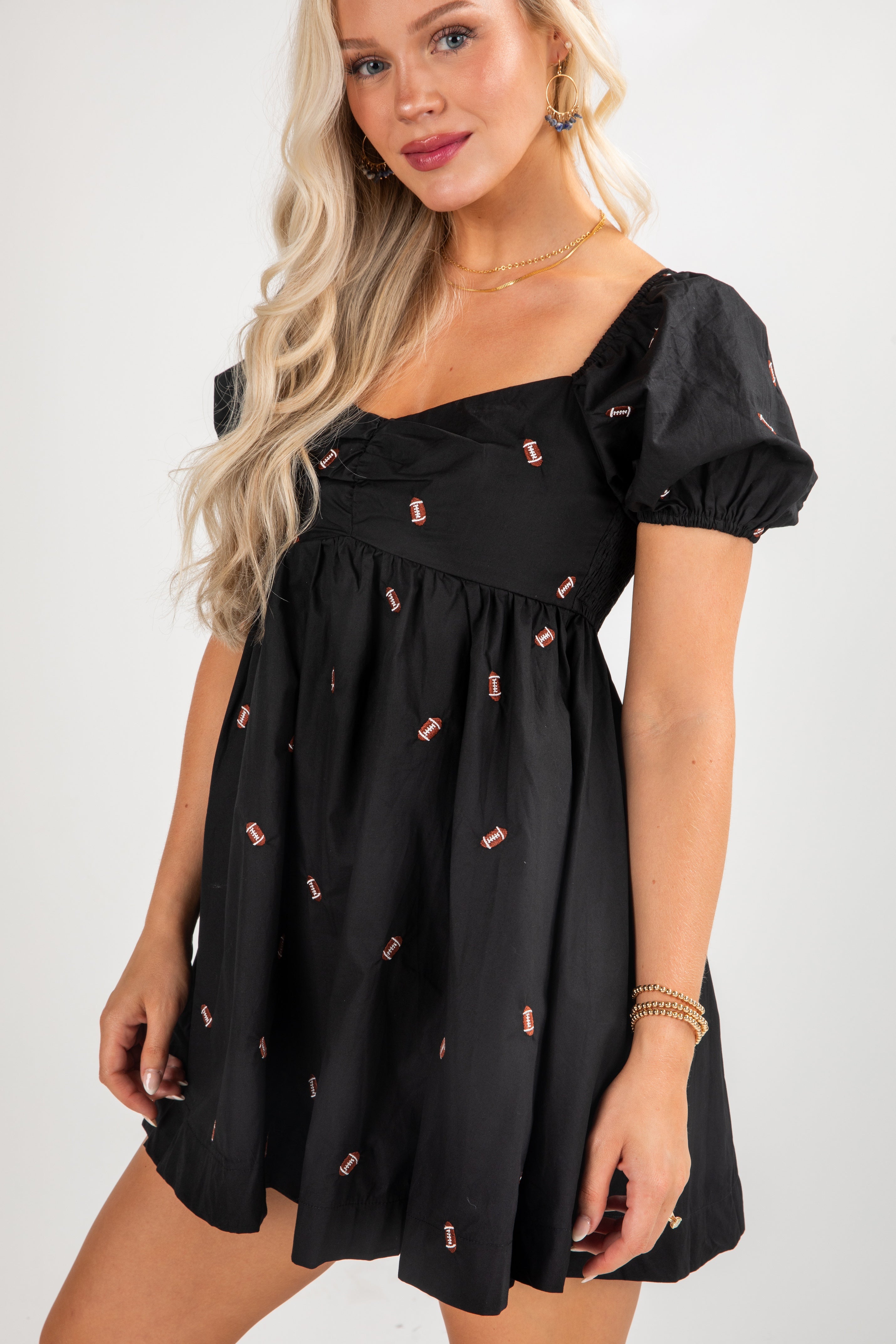 Woman wearing a black dress with small red patterns on a white background