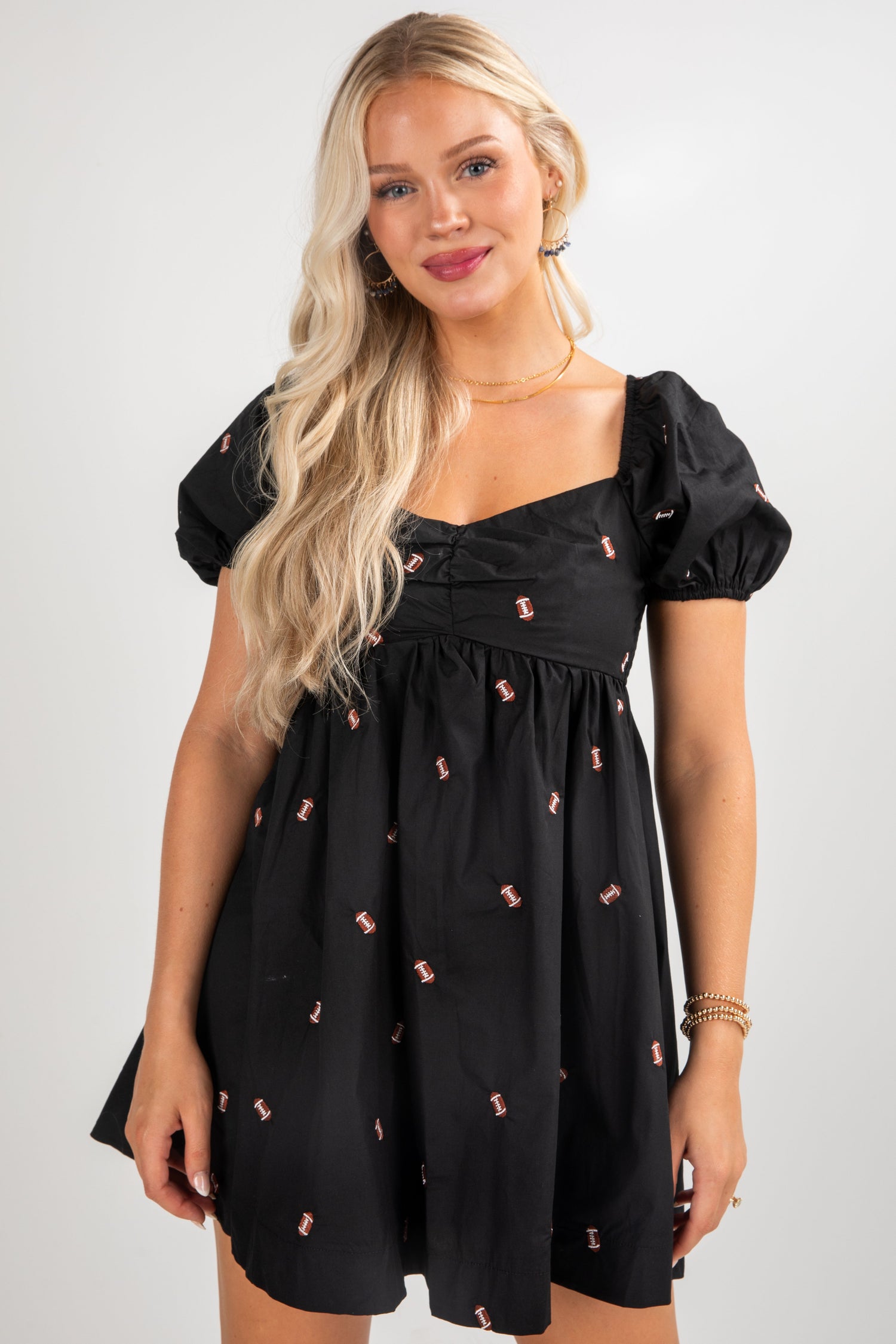 Woman wearing a black dress with small pink patterns on a white background