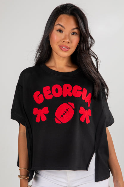 Woman wearing a black t-shirt with red &