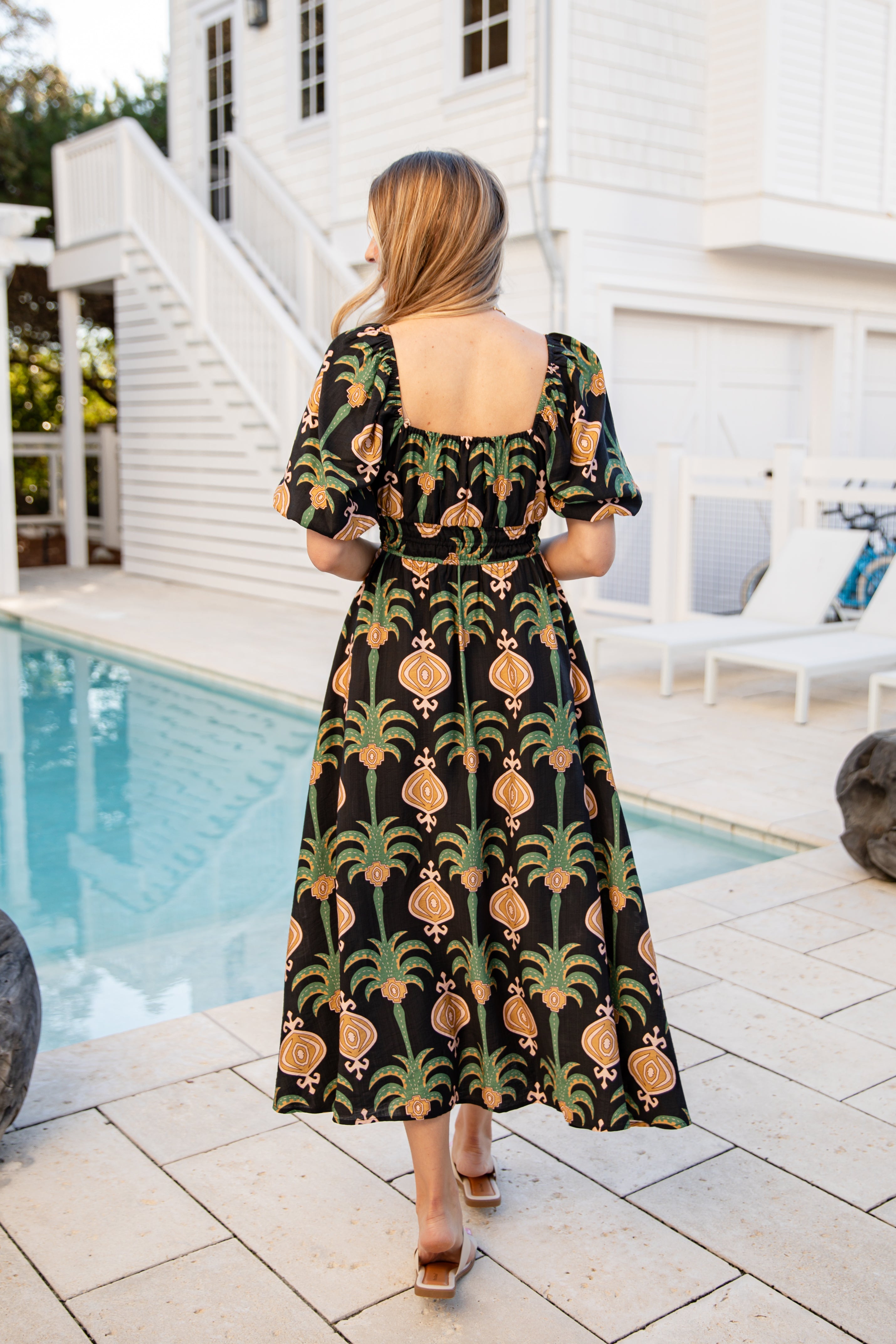 Woman wearing a patterned dress by a poolside