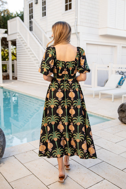 Woman wearing a patterned dress by a poolside