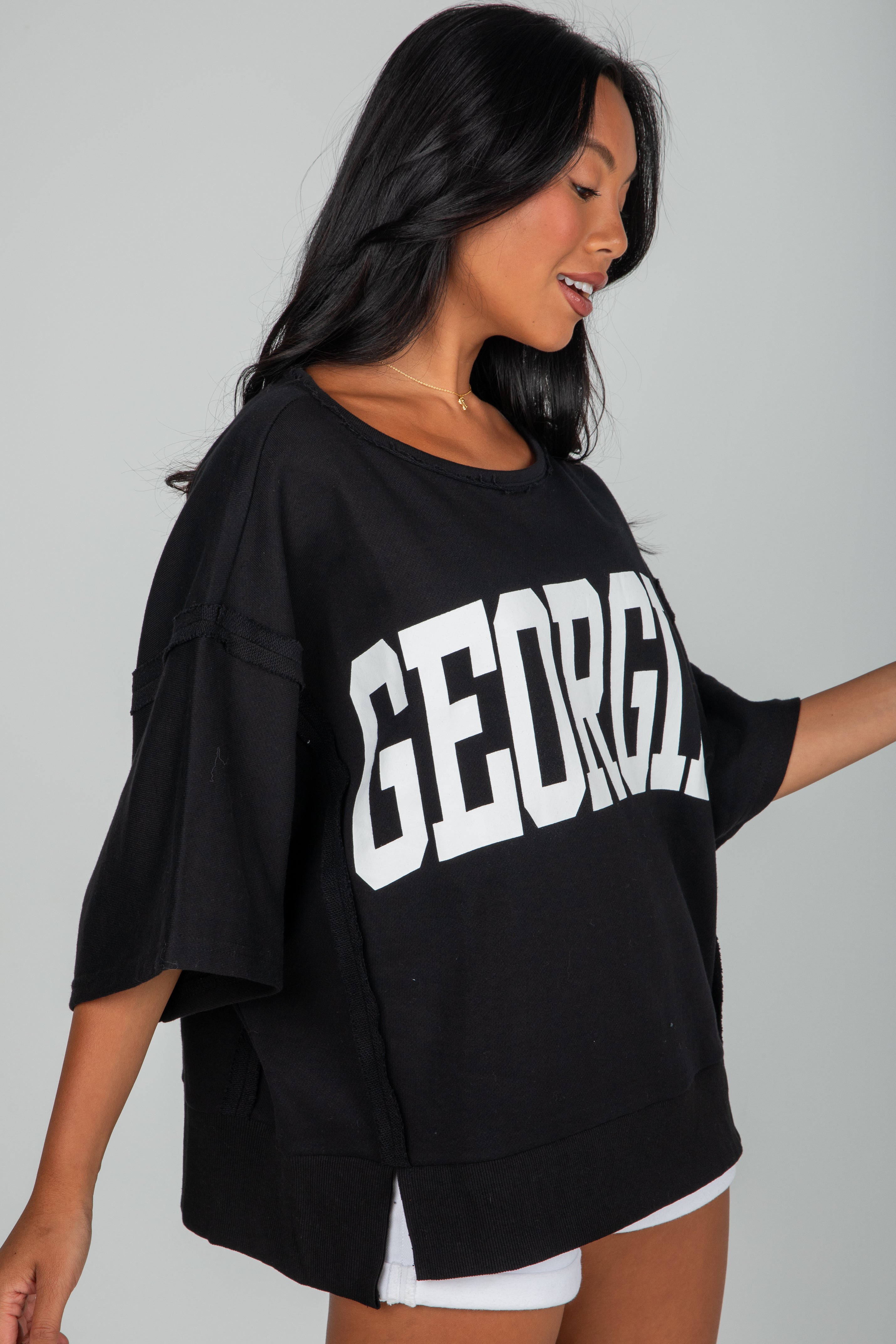 Woman wearing a black oversized sweatshirt with &