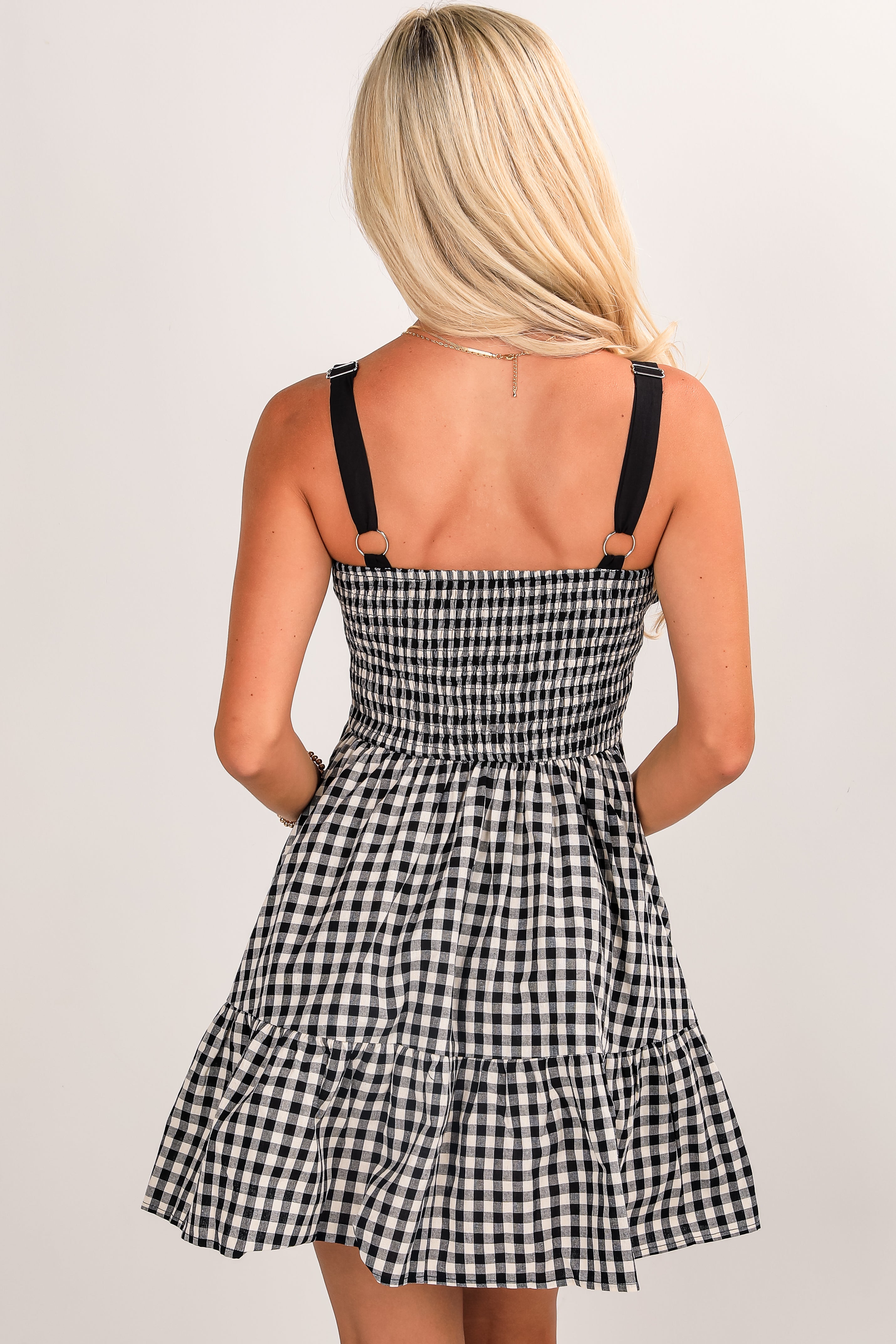 Black and white checkered dress with thin straps on a plain background