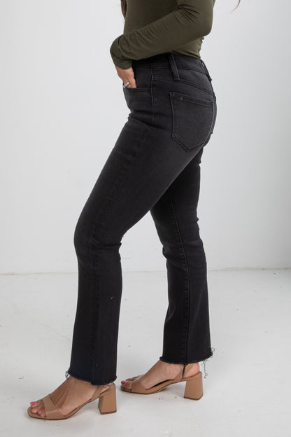 Person wearing black jeans and a green top on a white background