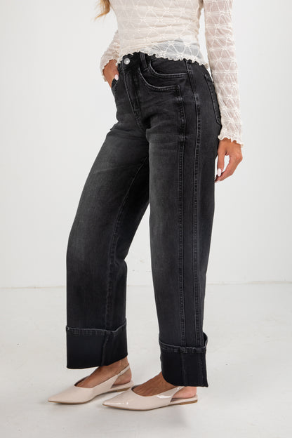 Person wearing black jeans and a white lace top on a white background