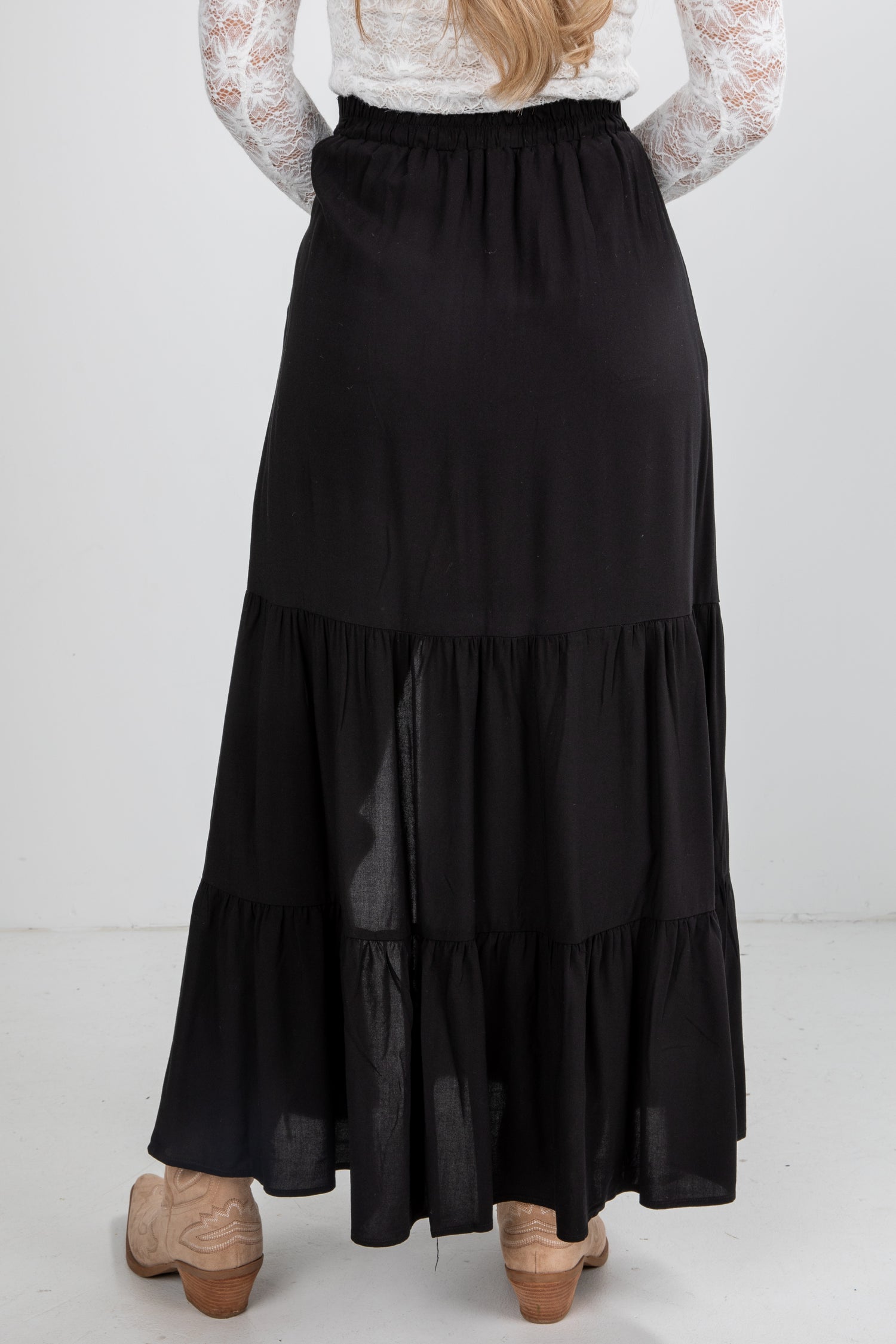 Black tiered skirt worn by a person on a white background