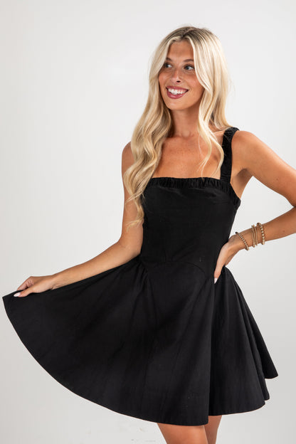 Woman wearing a black dress against a white background