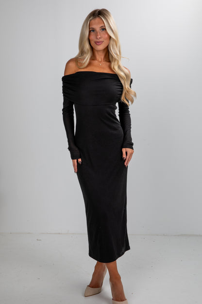 Woman wearing a black off-shoulder long-sleeve dress against a white background