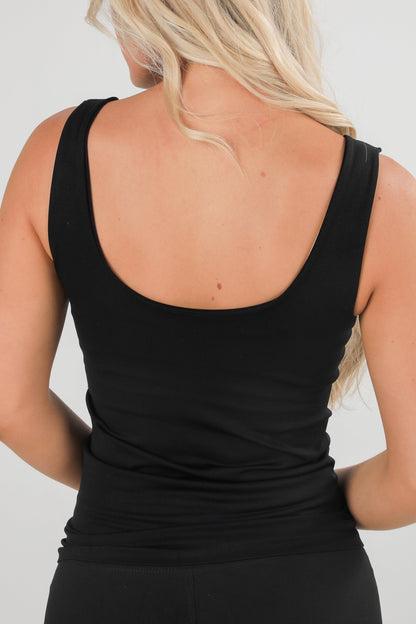Black tank top worn by a person on a plain background
