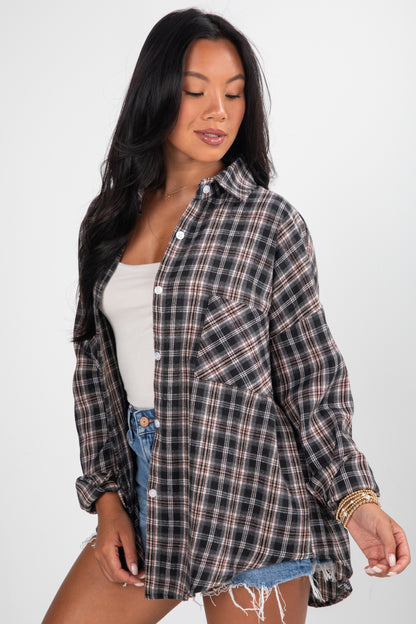 Woman wearing a plaid shirt over a white top and denim shorts on a white background