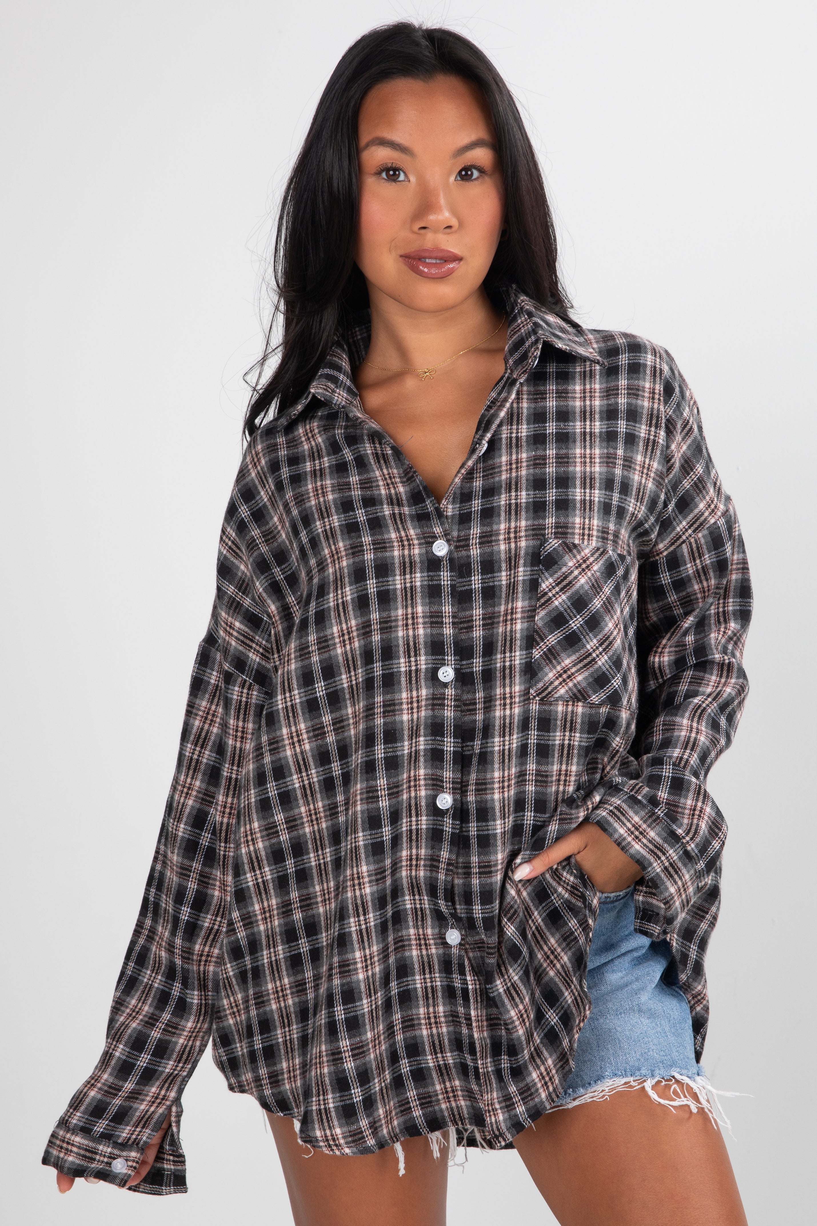 Woman wearing a plaid shirt and denim shorts on a white background