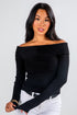 Woman wearing a black off-shoulder top against a white background