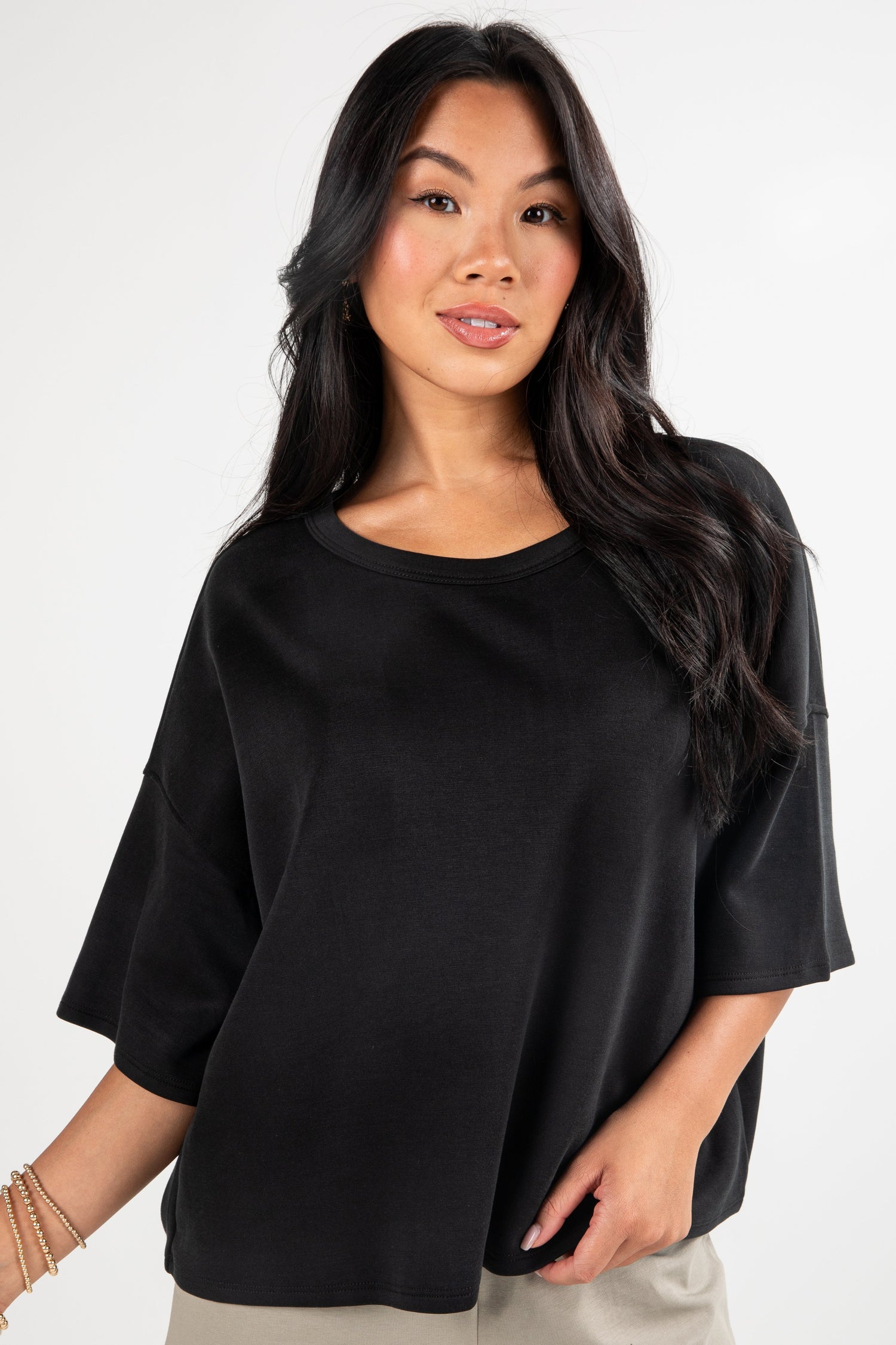 Woman wearing a black oversized shirt against a white background
