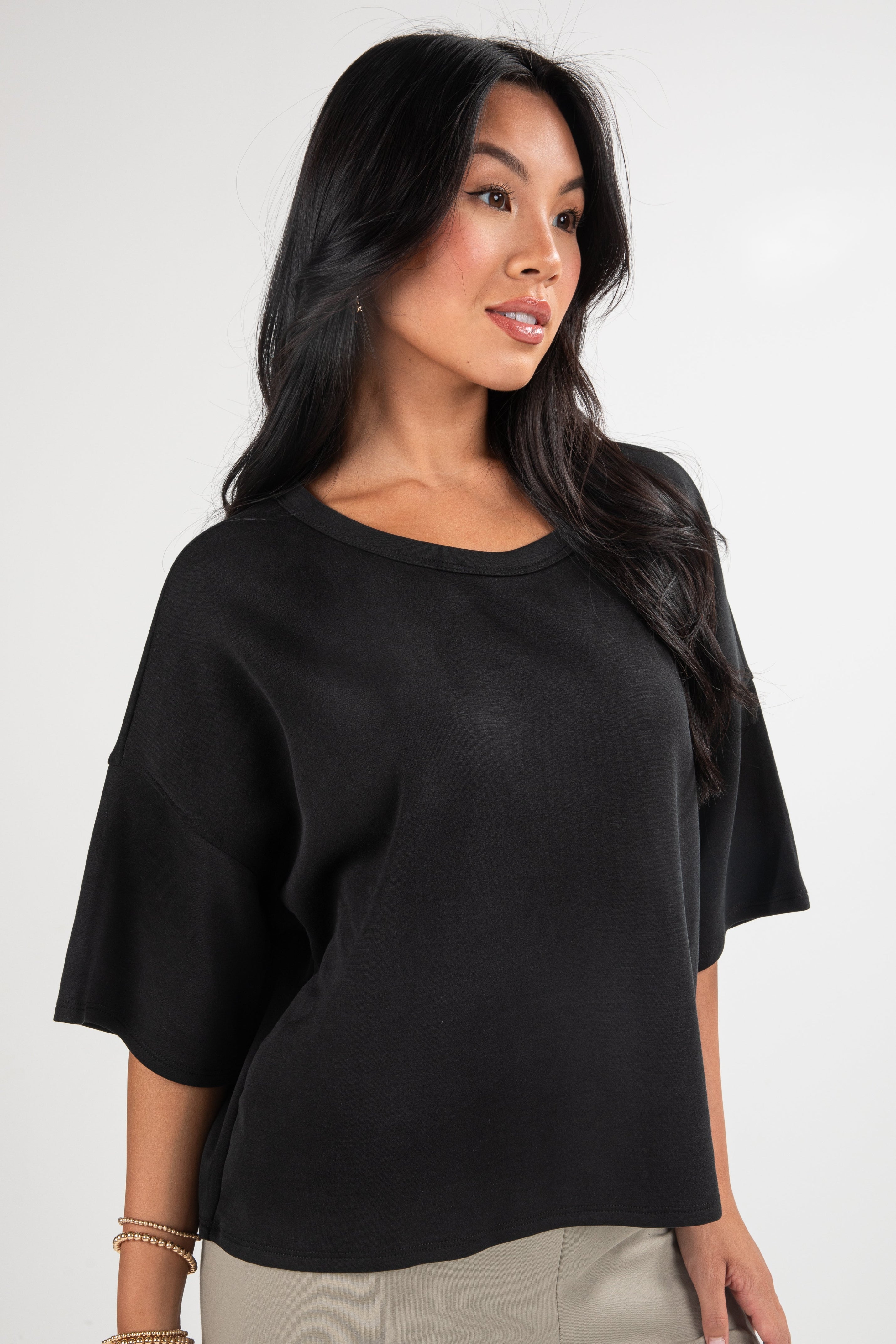 Woman wearing a black top against a white background