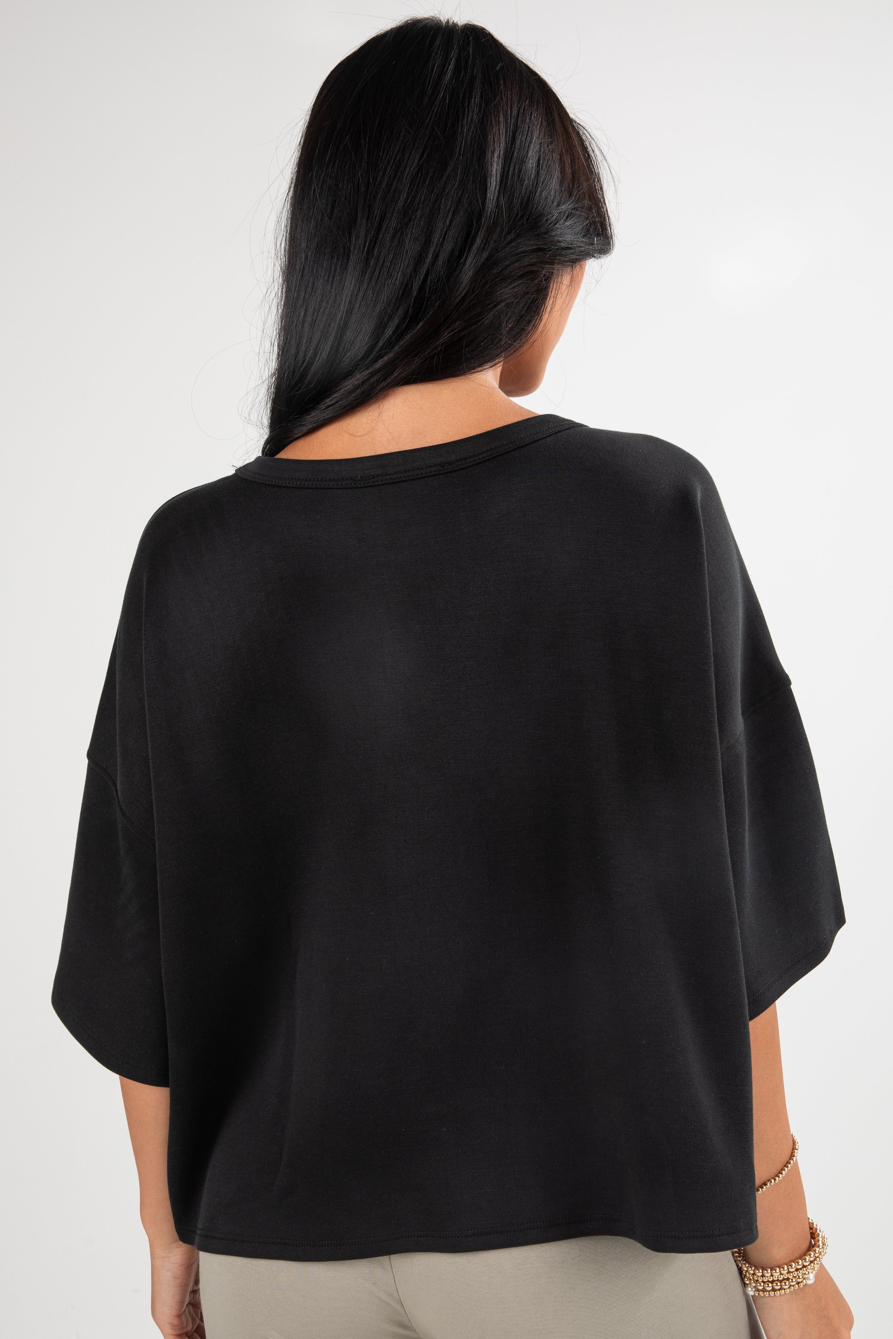 Person wearing a black oversized shirt on a white background