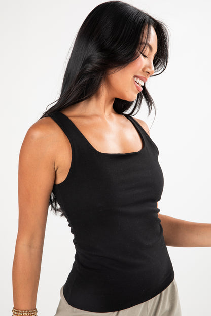 Woman wearing a black tank top on a white background