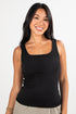 Woman wearing a black tank top against a white background