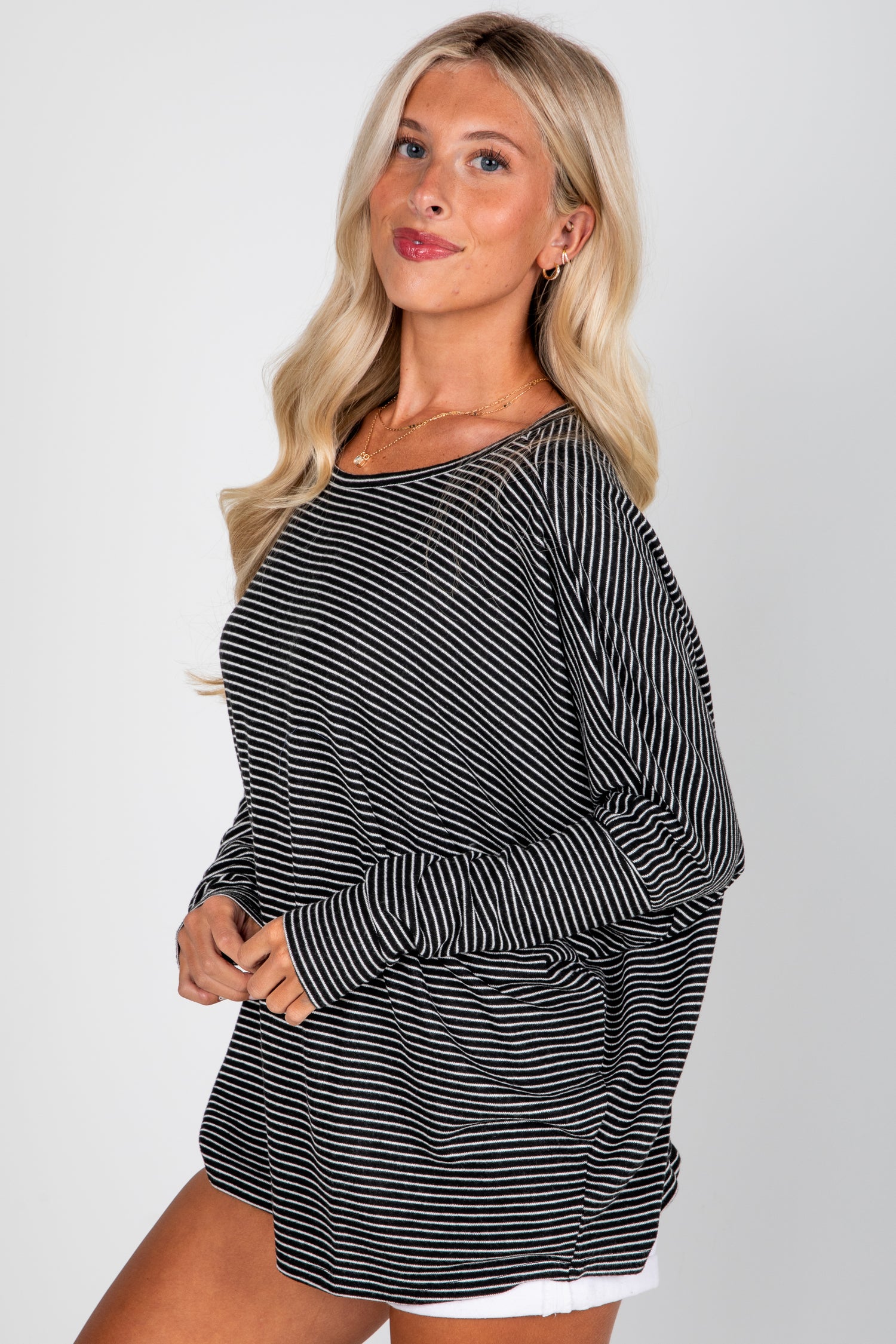 Woman wearing a black and white striped dress against a plain background