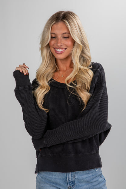 Woman wearing a black sweater with a plain background
