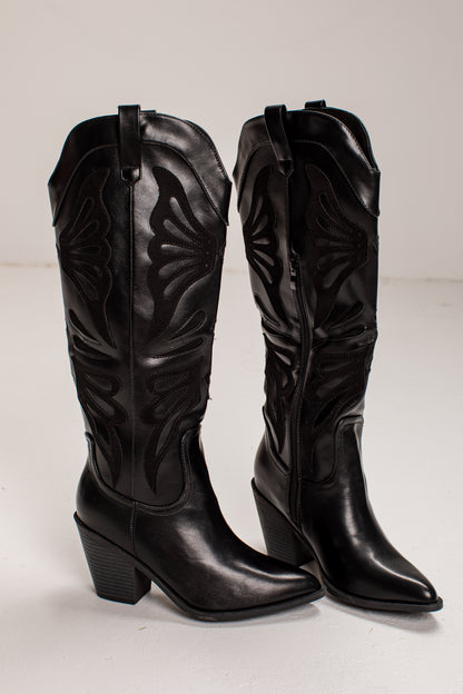 A pair of black leather knee-high cowboy boots with pointed toes, low block heels, and decorative western-style stitching, shown against a plain light background.