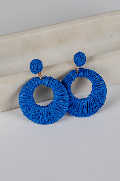 Blue hoop earrings on a light gray surface