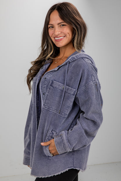 Woman wearing a blue corduroy jacket against a plain background