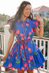 Woman wearing a blue floral dress on a balcony